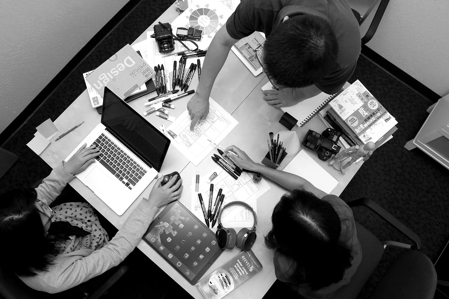 Team planning a shoot around a table of storyboards and gear